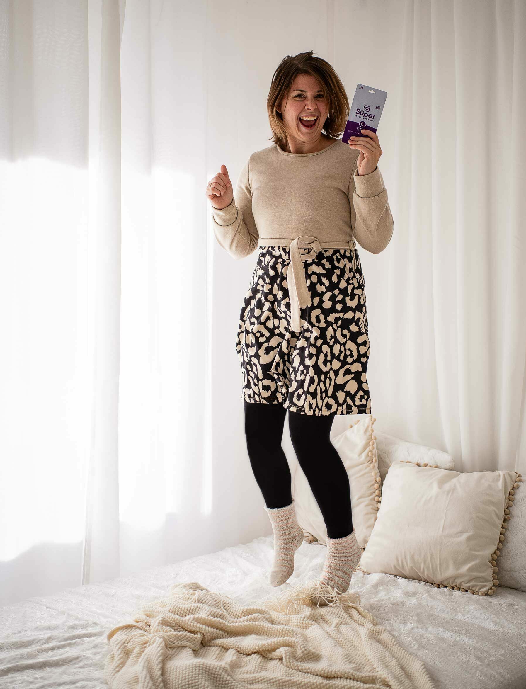 Frau springt auf dem Bett