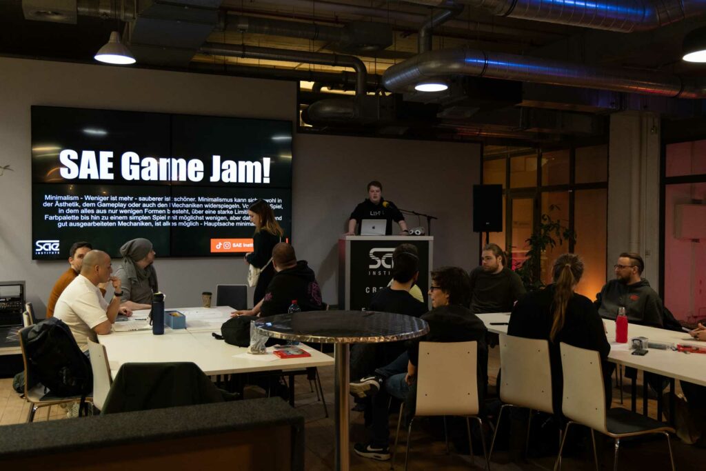 Student steht am Pult auf Bühne und führt in die Veranstalung ein.