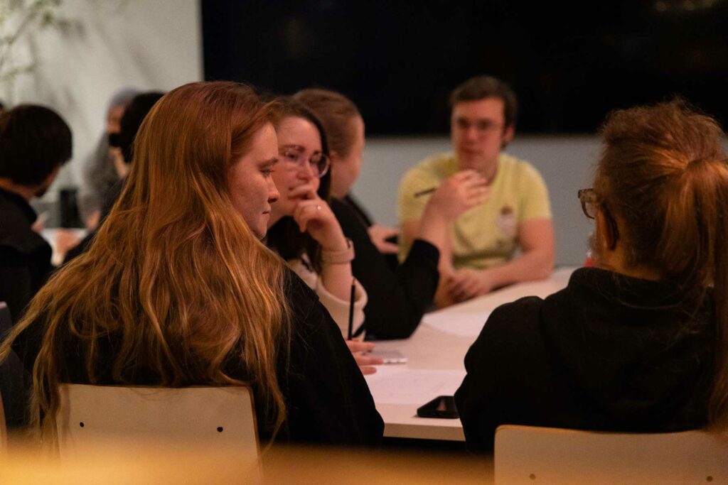 Menschen sitzen zusammen am Tisch und unterhalten sich