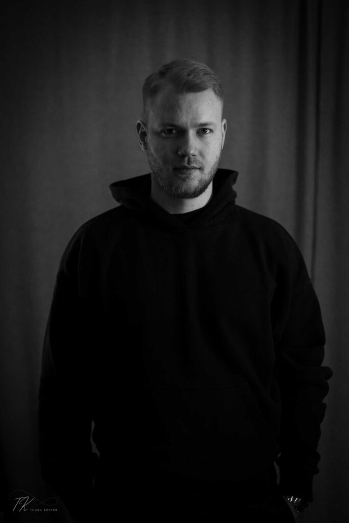 Schwarz weißes Bild eines jungen Mannes, die direkt in die Kamera schaut.