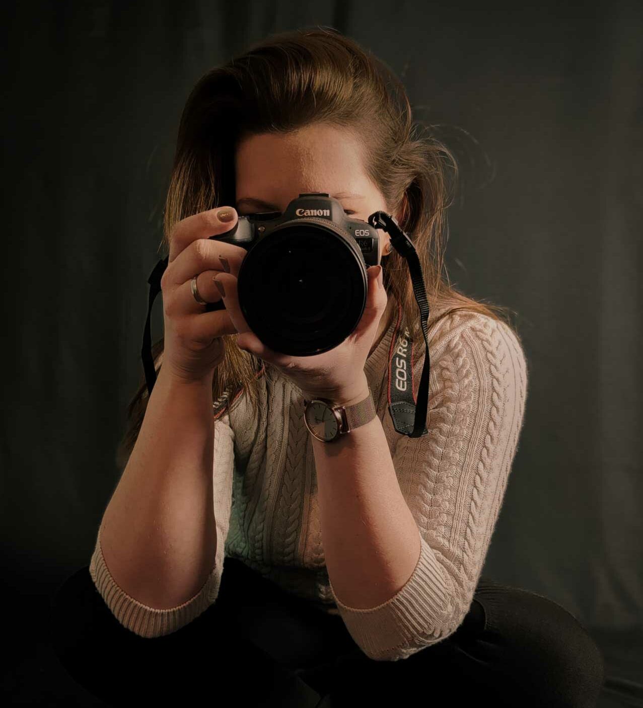 Fotografin hält eine Kamera von Canon direkt vor dem Gesicht.