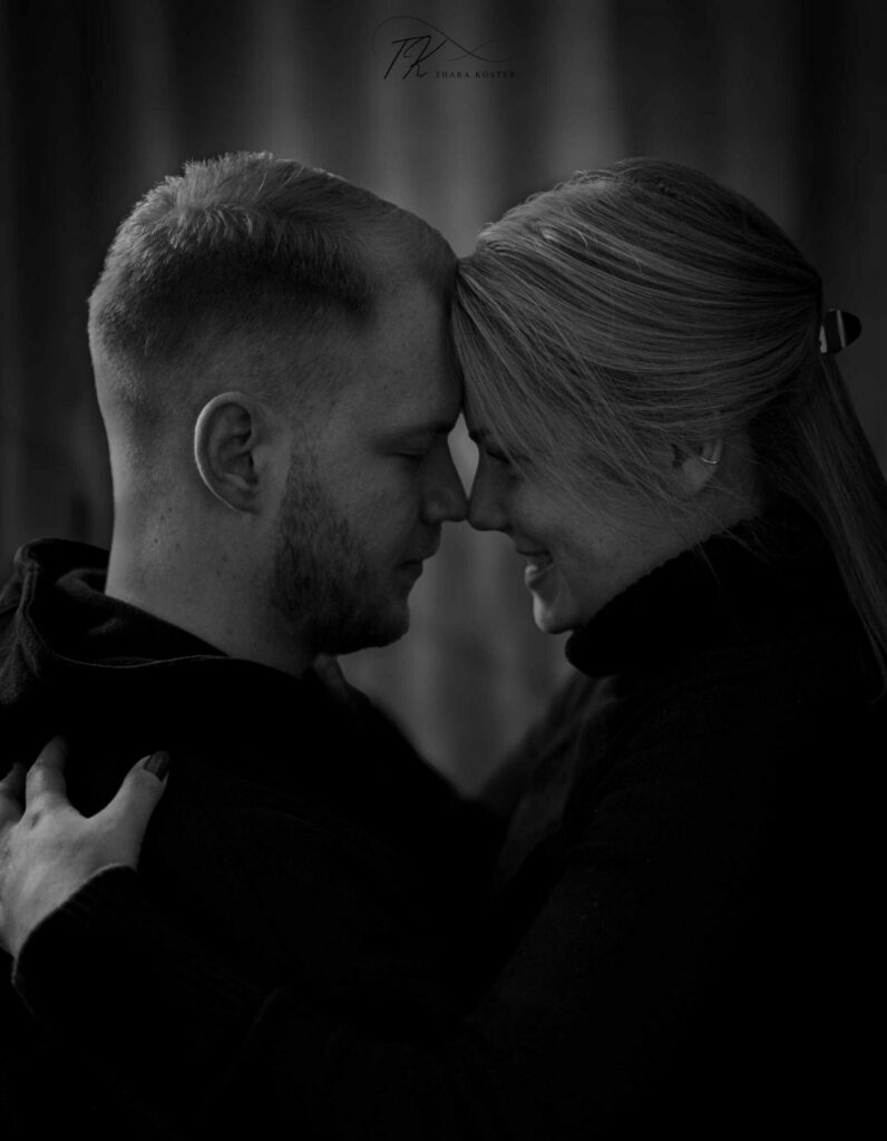 Schwarz weißes Bild von einem Paar bei einem Paarshooting, die die Stirn aneinander legen
