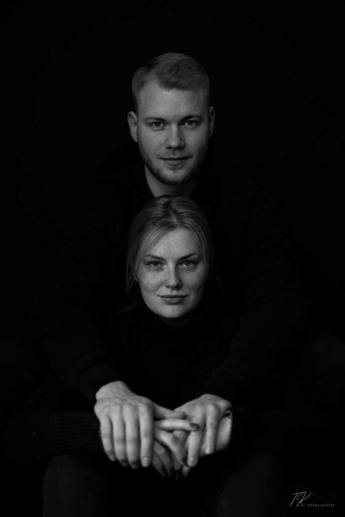 Zwei Personen bei Paarshooting mit dunklem Hintergrund in schwarz weiß.